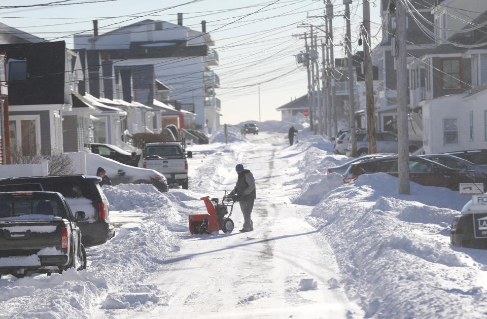Snow is piled high and cleanup is under way at Hampton Beach Sunday, Jan. 30, 2022 following a blizzard the previous day.