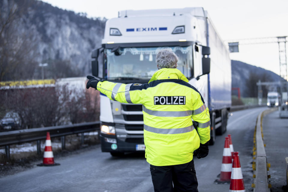 A federal police officer directs a truck driver coming from Austria into the border checkpoint on the A93 motorway near Kiefersfelden, Germany, Monday, Feb. 12, 2021. The tightened German entry rules at the border with the Austrian state of Tyrol to protect against the spread of the coronavirus came into force on Sunday night. Photo: Matthias Balk/dpa via AP)