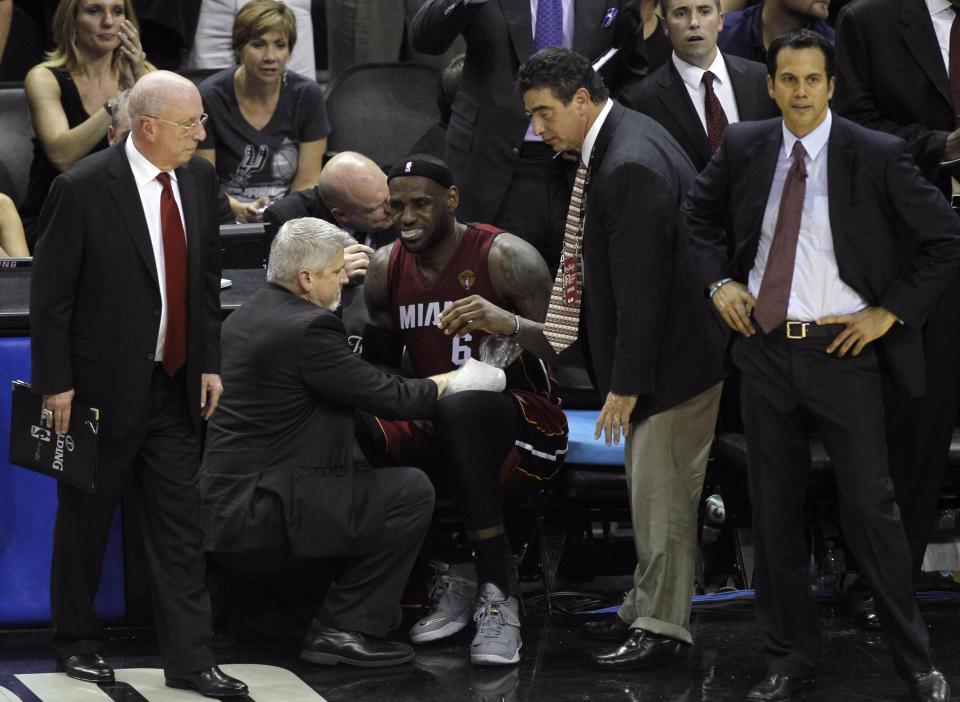 Miami Heat's LeBron James sits on the bench after hurting his leg during the fourth quarter against the San Antonio Spurs in Game 1 of their NBA Finals basketball series in San Antonio