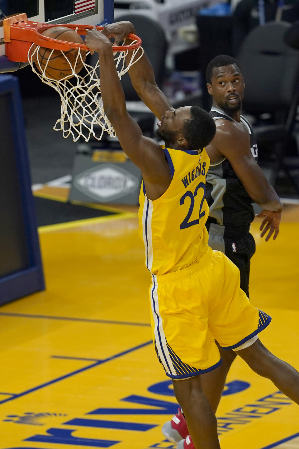 Golden State Warriors forward Andrew Wiggins (22) dunks against Sacramento Kings forward Harrison Barnes during the first half of an NBA basketball game in San Francisco, Monday, Jan. 4, 2021. (AP Photo/Jeff Chiu)