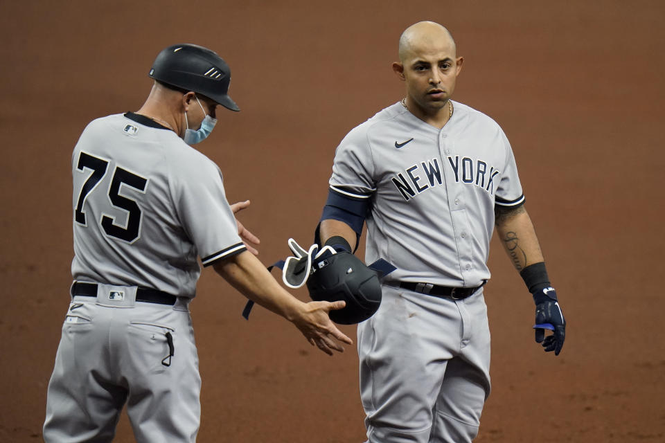 New York Yankees' Rougned Odor, right, hands his helmet to first base coach Reggie Willits after popping out against the Tampa Bay Rays during the second inning of a baseball game Sunday, April 11, 2021, in St. Petersburg, Fla. (AP Photo/Chris O'Meara)