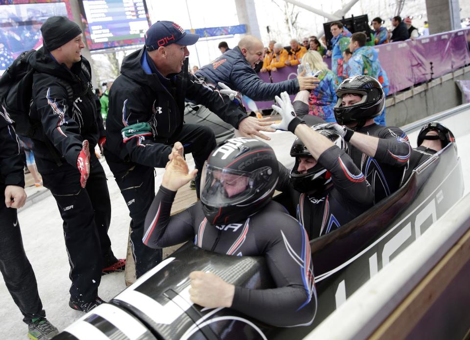 The team from the United States USA-1, with Steven Holcomb, Curtis Tomasevicz, Steven Langton and Christopher Fogt, celebrate after they won the bronze medal during the men's four-man bobsled competition final at the 2014 Winter Olympics, Sunday, Feb. 23, 2014, in Krasnaya Polyana, Russia. (AP Photo/Jae C. Hong)