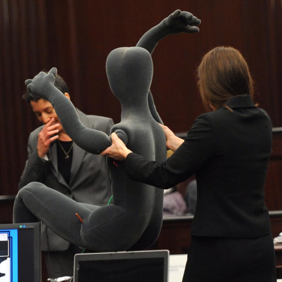 Associate Medical Examiner Stacey Simons, left, waits as a anatomical form is placed near the jury to show the projectile paths in Jordan Davis' body during testimony in the trial of Michael Dunn in Jacksonville, Fla., Monday, Feb. 10, 2014. The prosecution has rested in the trial of Dunn charged with killing Davis following an argument over loud music outside a Jacksonville convenience store in 2012. (AP Photo/The Florida Times-Union, Bob Mack, Pool)
