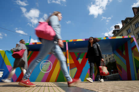 People walk past a painting wall on which reads "Amiens for Youth 2020" in Amiens, France, May 16, 2019. Picture taken May 16, 2019. REUTERS/Pascal Rossignol