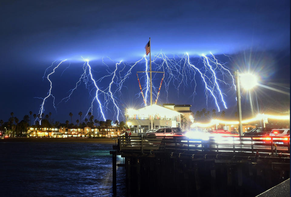 This time exposure photo provided by the Santa Barbara County Fire Department shows a series of lightning strikes over Santa Barbara, Calif., seen from Stearns Wharf in the city's harbor, Tuesday evening, March 5, 2019. A storm soaking California on Wednesday could trigger mudslides in wildfire burn areas where thousands of residents are under evacuation orders, authorities warned. (Mike Eliason/Santa Barbara County Fire Department via AP)