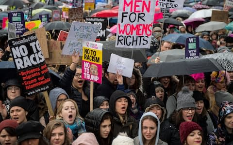 Women's rights demonstrators hold placards and chant slogans during the Time's Up rally  - Credit: Getty 