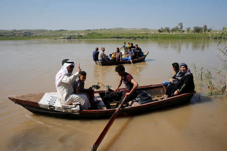 Displaced Iraqis from Mosul cross the Tigris by boat as flooding after days of rainfall has closed the city's bridges, at the village of Thibaniya, south of Mosul, Iraq April 16, 2017. REUTERS/Muhammad Hamed