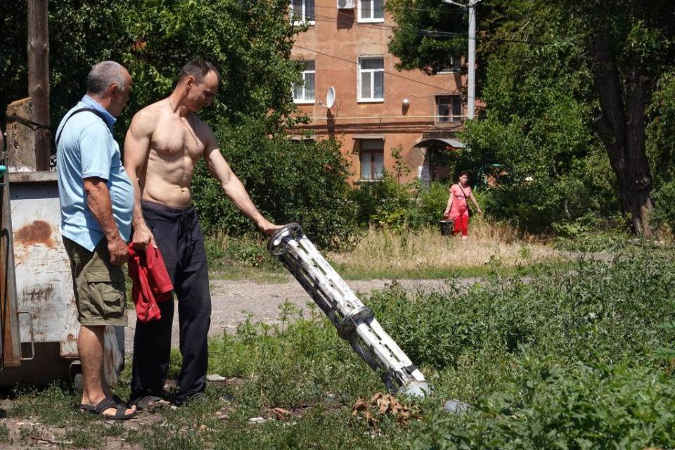 People look at the remnants of a Russian missile that dropped cluster bombs on a residential housing complex in Sloviansk, Ukraine, on June 27, 2022. (Photo by Scott Olson/Getty Images)