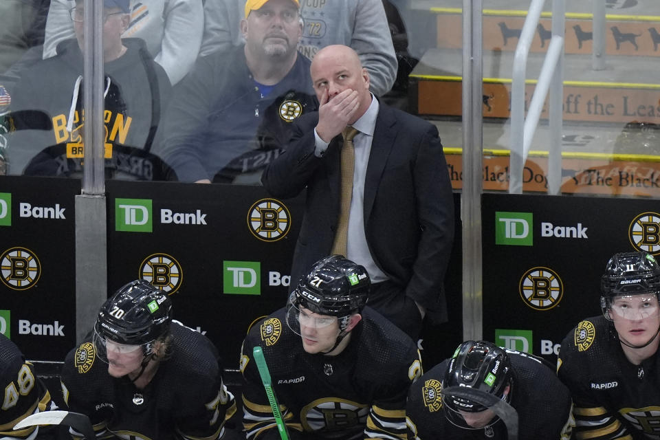 Boston Bruins head coach Jim Montgomery, center top, looks up toward the scoreboard from behind the bench as his team trails the Seattle Kraken in the third period of an NHL hockey game, Thursday, Feb. 15, 2024, in Boston. (AP Photo/Steven Senne)