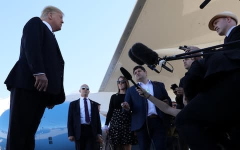 Donald Trump talks to reporters before leaving Nevada - Credit: Jonathan Ernst/Reuters