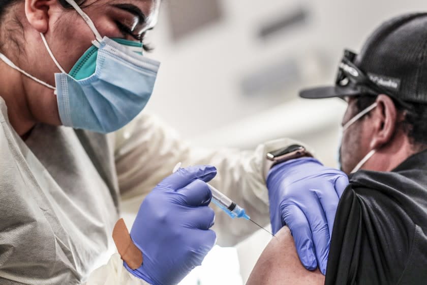 Bell, CA, Monday, April 5, 2021 - Victor Joaquin receives a Covid-19 vaccination from med tech Monica Lopez at the Bell Community Center. (Robert Gauthier/Los Angeles Times)