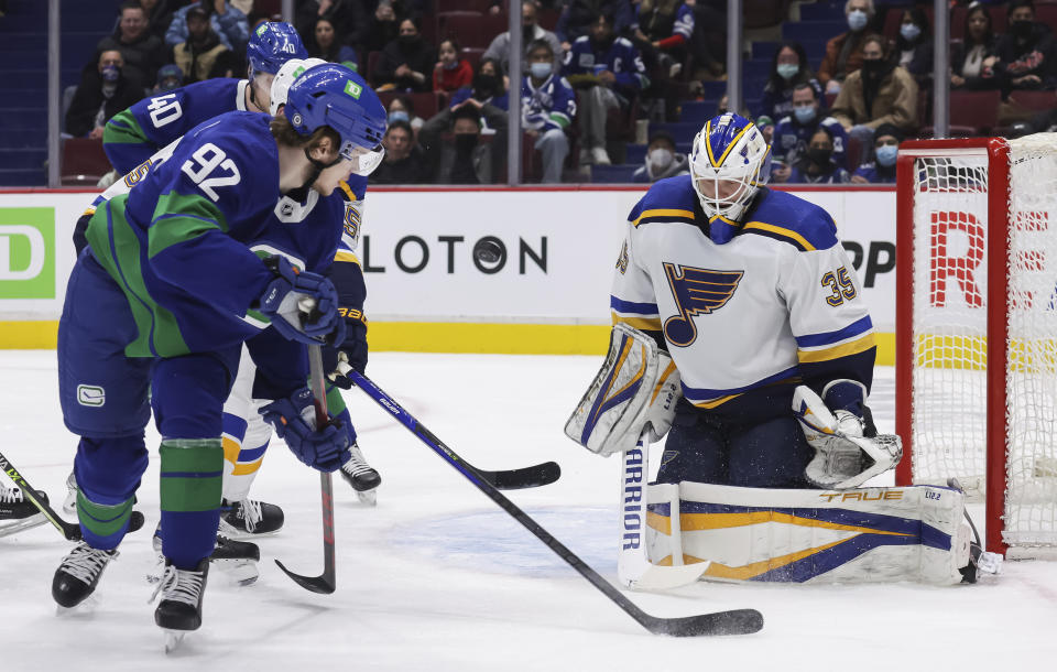 St. Louis Blues goalie Ville Husso (35), of Finland, stops Vancouver Canucks' Vasily Podkolzin (92), of Russia, during the second period of an NHL hockey game in Vancouver, British Columbia, Sunday, Jan. 23, 2022. (Darryl Dyck/The Canadian Press via AP)