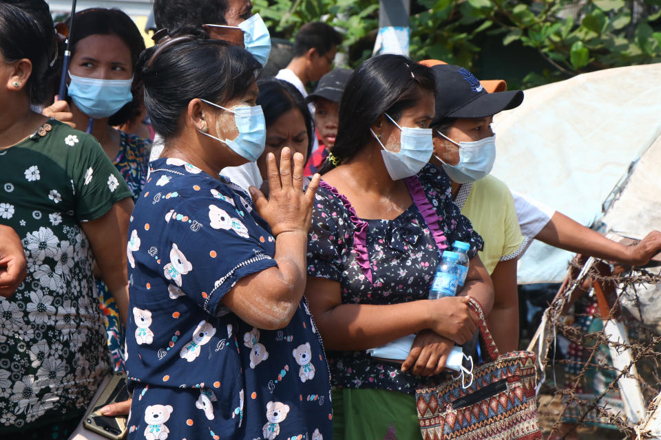 A woman makes a hand gesture while a convoy of buses with arrested protesters get out of Insein prison to go to an undisclosed location Wednesday, March 24, 2021 in Yangon, Myanmar. (AP Photo)