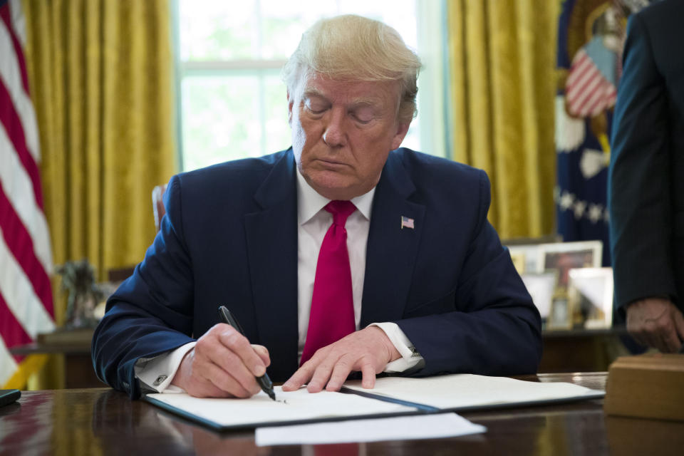 President Donald Trump signs an executive order to increase sanctions on Iran, in the Oval Office of the White House, Monday, June 24, 2019, in Washington. (AP Photo/Alex Brandon)
