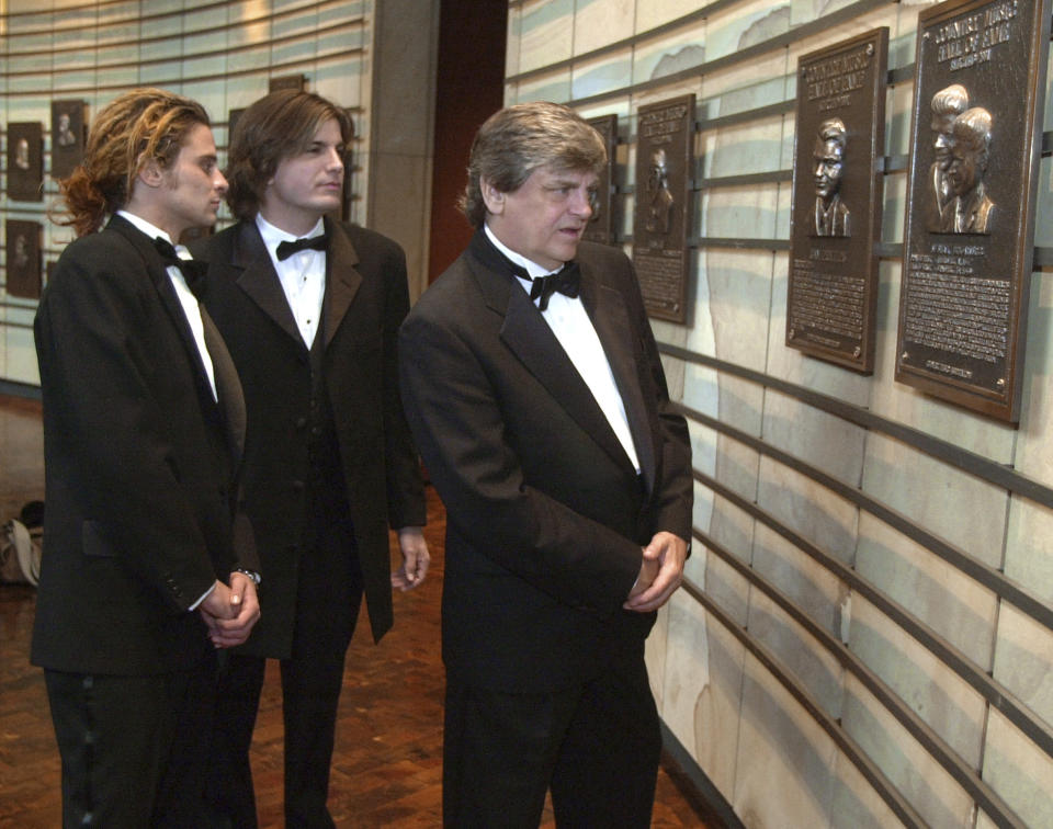 FILE - In this Oct. 4, 2001 file photo, Phil Everly, right, of the musical duo The Everly Brothers, looks at his plaque in the Country Music Hall of Fame along with his sons, Chris, left, and Jason, in Nashville, Tenn. Everly, who with his brother Don formed an influential harmony duo that touched the hearts and sparked the imaginations of rock 'n' roll singers for decades, including the Beatles and Bob Dylan, died Friday, Jan. 3, 2014. He was 74. Everly died of chronic obstructive pulmonary disease at a Burbank hospital, said his son Jason Everly. (AP Photo/Mark Humphrey, File)