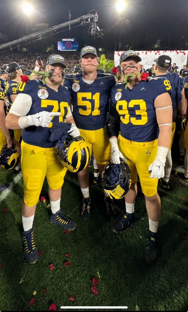Peter Simmons III celebrated with teammates following Michigan's 27-20 overtime won over Alabama
