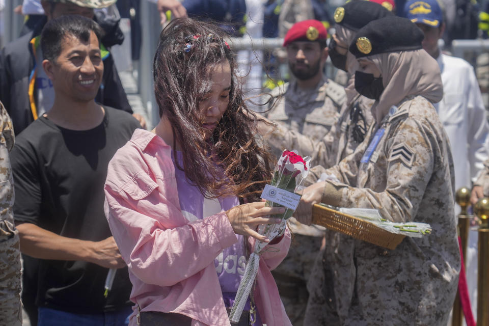 Chinese evacuees are welcomed by flowers as they arrive at Jeddah port, Saudi Arabia, Wednesday, May 3, 2023. Exhausted Sudanese and foreigners joined growing crowds at Sudan's main seaport Tuesday, waiting to be evacuated from the chaos-stricken nation. After more than two weeks of fighting, areas of the capital of Khartoum appear increasingly abandoned. (AP Photo/Amr Nabil)