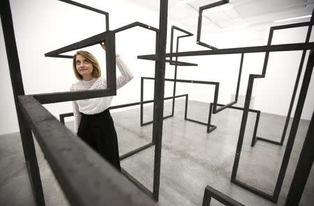 A member of the gallery staff poses for a photograph with a piece called "Run", by artist Antony Gormley, which forms part of an exhibition entitled "Fit", at the White Cube gallery in London, Britain September 29, 2016. REUTERS/Peter Nicholls