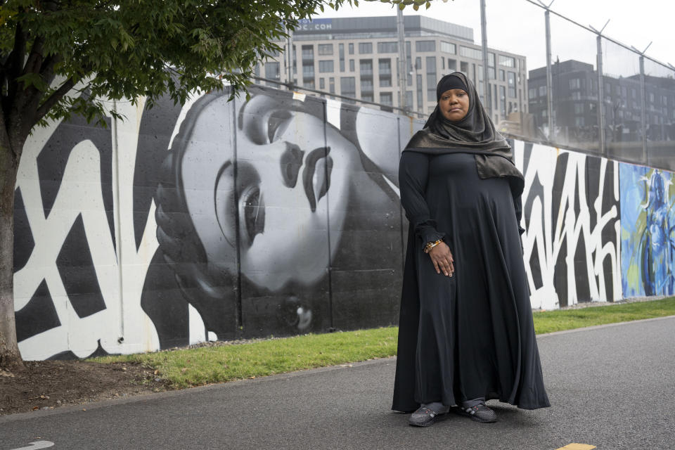 Asiyah Timimi, whose husband was stabbed to death in January 2021, stands along the murals on Metropolitan Branch Trail on Friday, Oct. 27, 2023 in Washington. (AP Photo/Kevin Wolf)