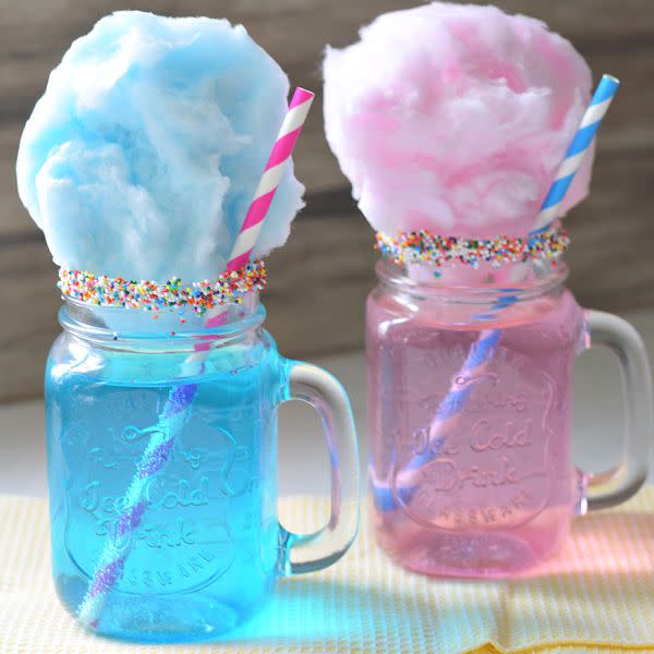 mason jars are filled with pink or blue liquid and topped with cotton candy and sprinkles, a great baby shower idea