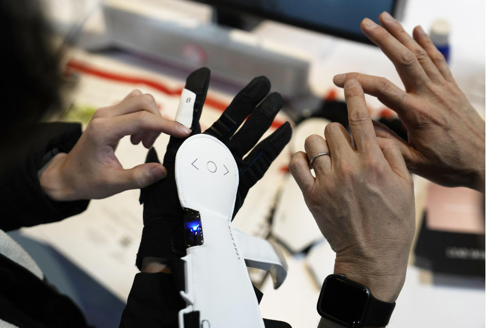 An attendee looks at Haptic Metaverse Gloves by AI Silk during the CES tech show Thursday, Jan. 5, 2023, in Las Vegas. (AP Photo/John Locher)