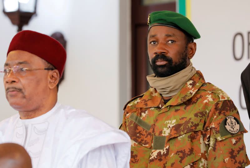 FILE PHOTO: Colonel Assimi Goita, leader of Malian military junta, looks on while he stands behind Niger's President Mahamadou Issoufou during a photo opportunity after the Economic Community of West African States (ECOWAS) consultative meeting in Accra