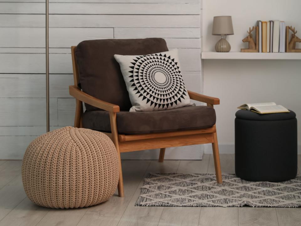 Pouf next to a brown chair with pillow with circular pattern on it