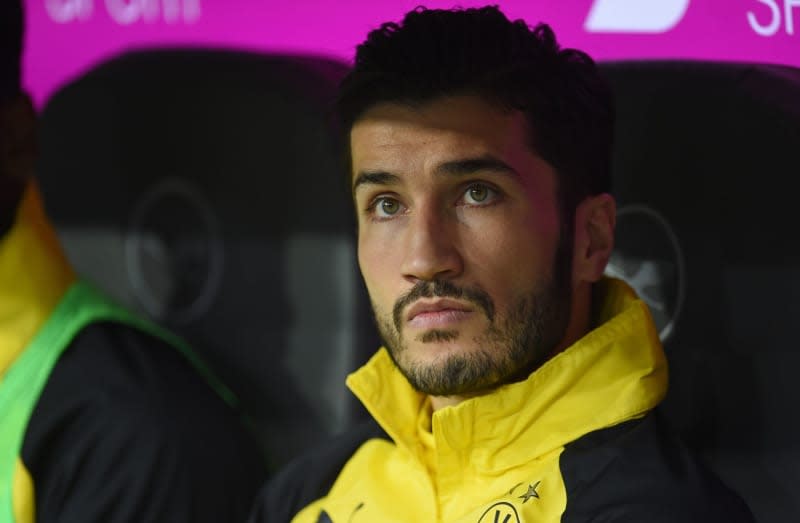 Dortmund's Nuri Sahin sits on the bench at the start of the German Bundesliga soccer match between Bayern Munich and Borussia Dortmund at the Allianz Arena. Former Borussia Dortmund players Nuri Sahin and Sven Bender are set to return to the Bundesliga club as assistant coaches, media reports said on Friday. Andreas Gebert/dpa