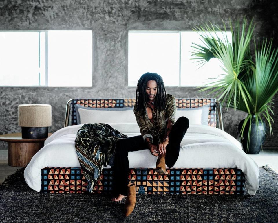 Musician Lenny Kravitz sits surrounded by home decor pieces he helped design. 