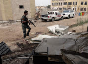 A policeman stands guard near a classroom damaged after a suicide attack in Baghdad’s eastern neighborhood of Ur, Iraq, Sunday, April 20, 2014. A suicide bomber with an explosives belt attacked the main gate of a Shiite private college while three militants attacked the back gate, leaving several people dead and over a dozen people wounded. Security forces killed all of the attackers. (AP Photo/Khalid Mohammed)