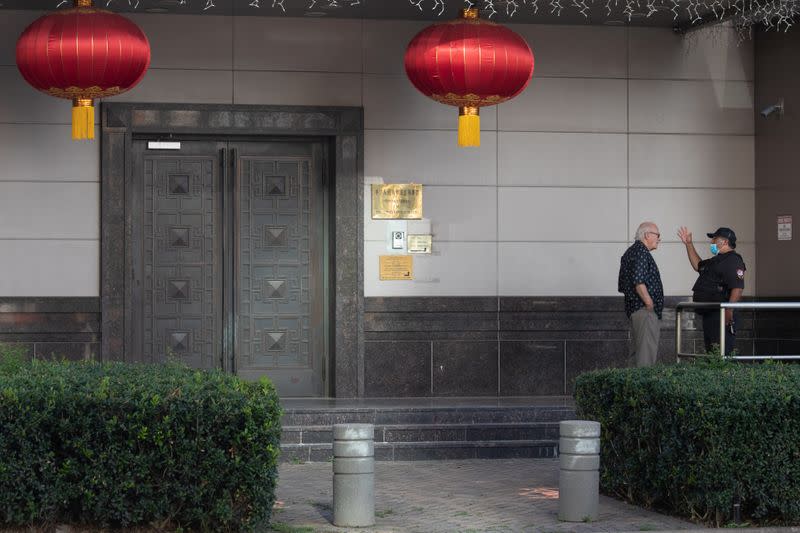 A man speaks to a security guard outside the China Consulate General in Houston, Texas