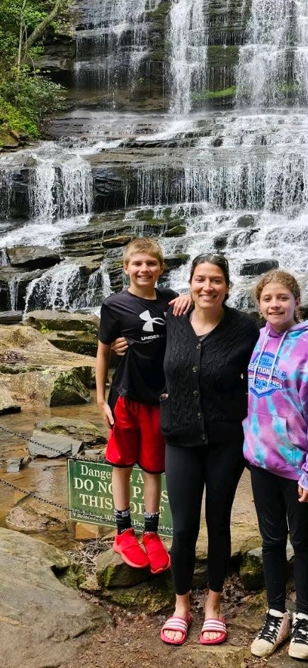 Racheal Blakney, center, with her twins, Cyrus and Piper Blakney, visit a waterfall in the Asheville area.