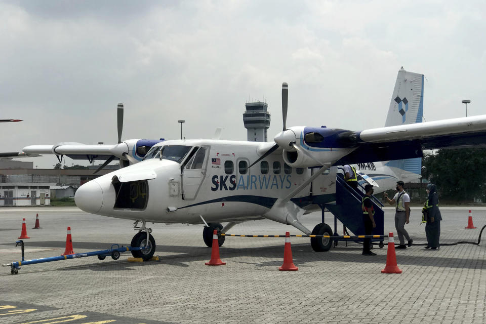 Grand staff prepare for the first flight of Twin Otter aircraft after a launching ceremony at Subang terminal in Kuala Lumpur, Malaysia, Tuesday, Jan. 25, 2022. New low-cost Malaysian carrier, SKS Airways, took to the skies Tuesday with short-haul flights to holiday island resorts as domestic travel rebounds after months of lockdown due to the COVID-19 pandemic last year. (AP Photo/Eileen Ng)