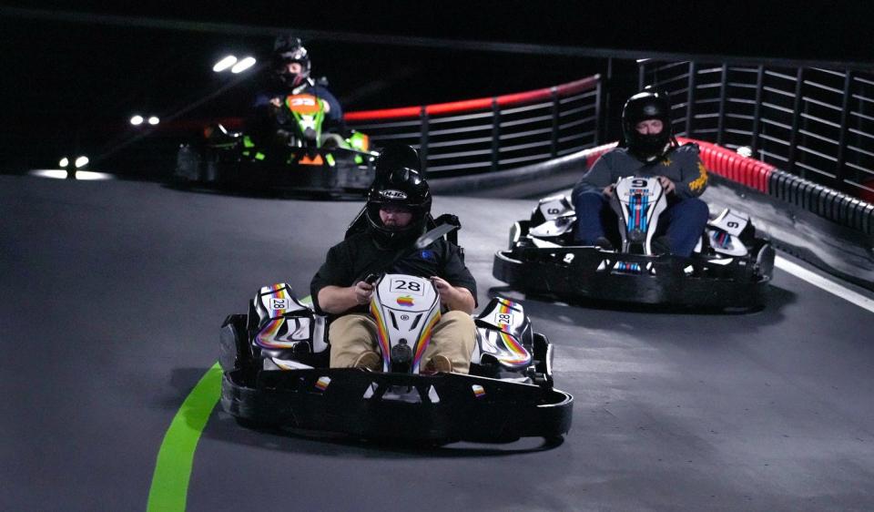 Jeff McIntosh, Patrick Kneeland and Josh Fairchild of Milford, Massachusetts, speed around the multi-level track in electric karts at R1 Indoor Karting.