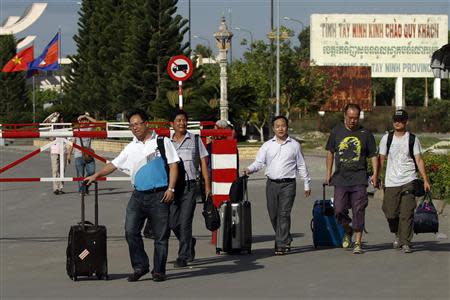 Chinese nationals cross to Cambodia from Vietnam at the Bavet international checkpoint in Svay Rieng province May 15, 2014. REUTERS/Samrang Pring