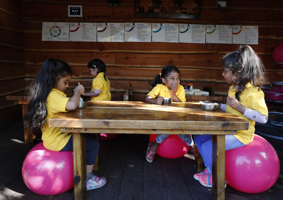 Children have breakfast at the Little Darling home-based Childcare after nurseries and primary schools partially reopen in England after the COVID-19 lockdown in London, Monday, June 1, 2020. (AP Photo/Frank Augstein)