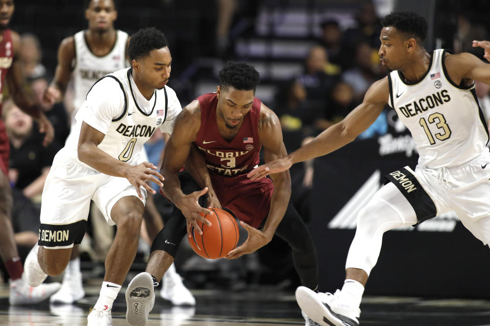 Florida State's Trent Forrest (3) reaches for the loose ball from Wake Forest's Brandon Childress (0) and Andrien White (13) in the first half of an NCAA college basketball game Wednesday, Jan. 8, 2020 in Winston-Salem, N.C. (AP Photo/Lynn Hey)