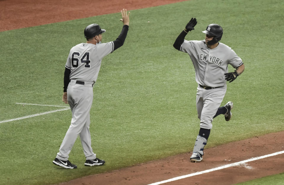 New York Yankees' Gary Sanchez, right, high fives third base coach Carlos Mendoza after hitting a solo home run off Tampa Bay Rays reliever Josh Fleming during the seventh inning of a baseball game Tuesday, May 11, 2021, in St. Petersburg, Fla. (AP Photo/Steve Nesius)