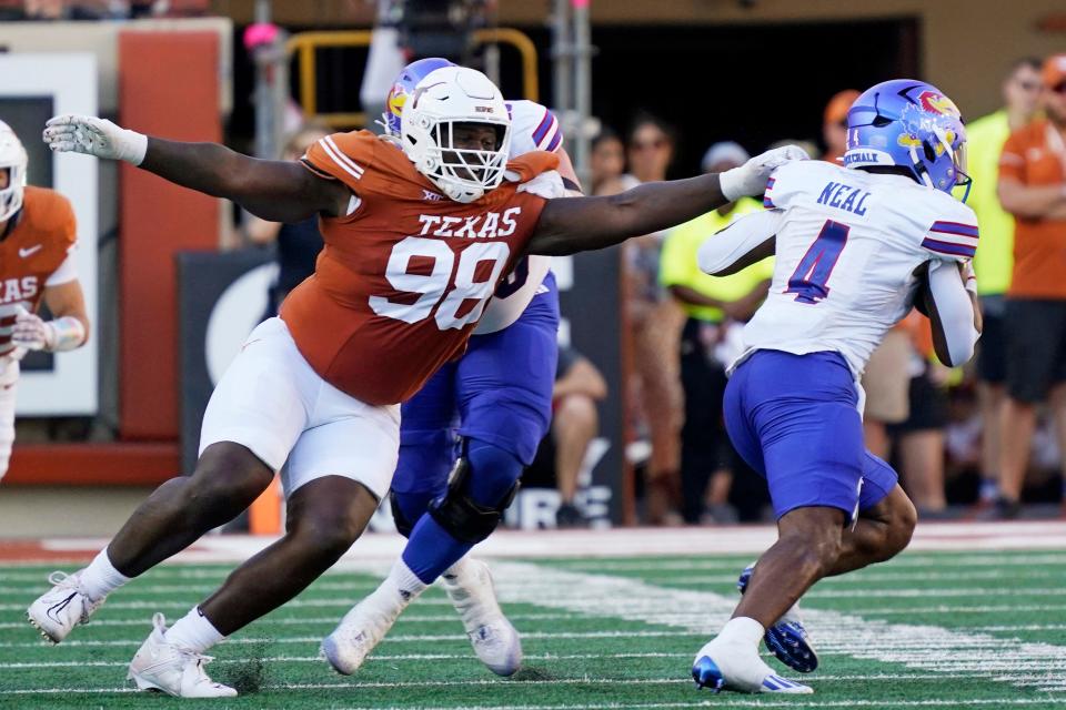 Texas defensive tackle Trill Carter reaches for Kansas running back Devin Neal in September at Royal-Memorial Stadium. Carter, who transferred in from Minnesota last offseason, has entered the portal again.