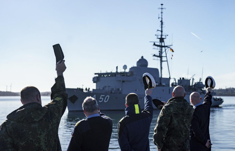 Navy soldiers wave to the naval service boat "Alster", which is leaving the naval port to reinforce the NATO northern flank, Eckernfoerde, Germany, Saturday, Feb. 26, 2022. In view of Russia's attack on Ukraine, the German Navy sends the reconnaissance ship "Alster" to reinforce NATO's northern flank. (Axel Heimken/dpa via AP)