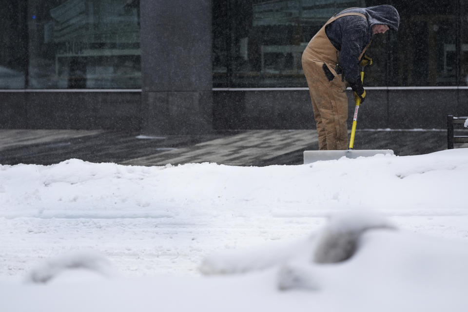A man shovels snow off a sidewalk Friday, Jan. 12, 2024, in Des Moines, Iowa. (AP Photo/Abbie Parr)