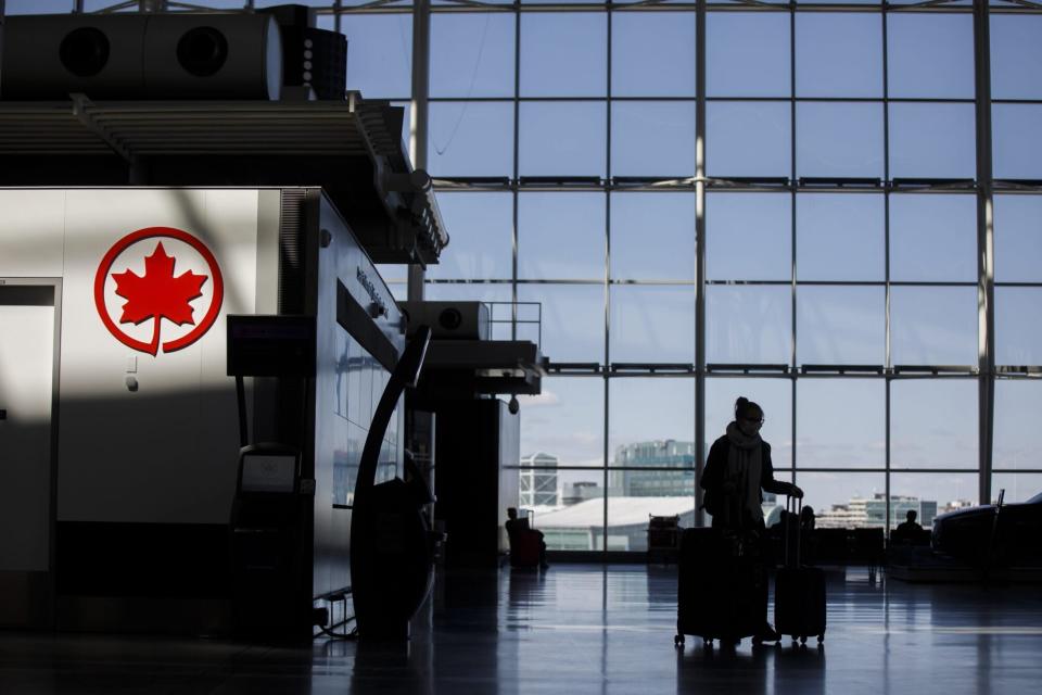 TORONTO, ON - APRIL 01: A passenger wheels her luggage near an Air Canada logo at Toronto Pearson International Airport on April 1, 2020 in Toronto, Canada. Air Canada announced it would temporarily lay off over 15,000 employees and reduce activity by up to 90 percent due to the coronavirus. (Photo by Cole Burston/Getty Images)