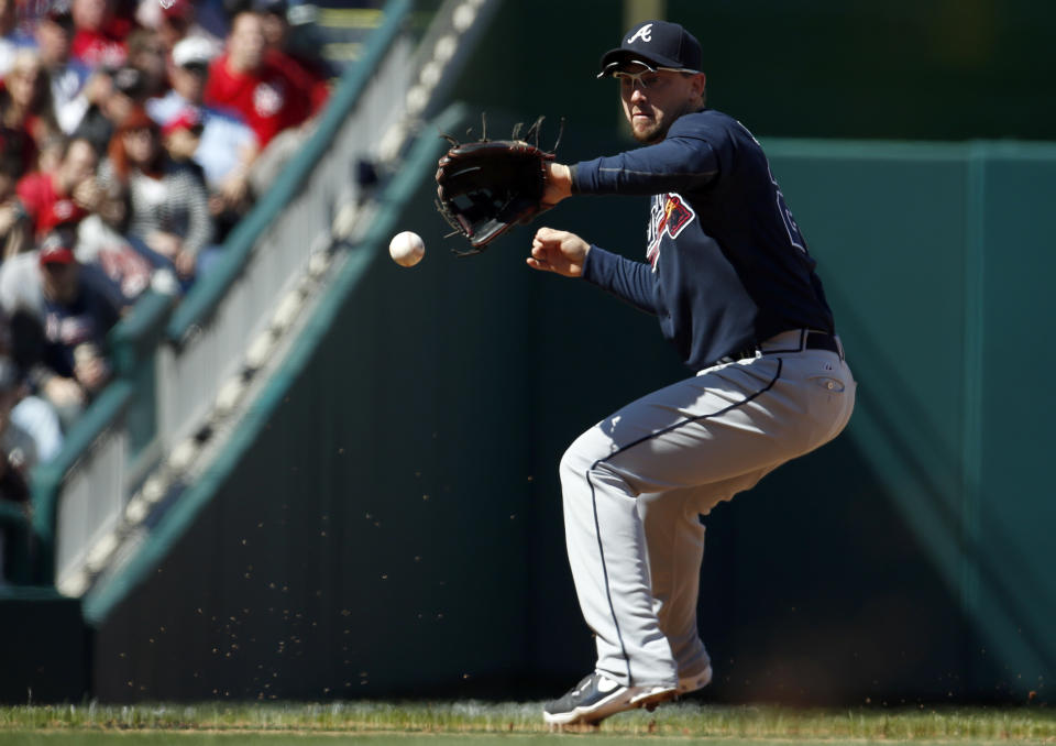 Atlanta Braves third baseman Chris Johnson fields a ball hit by Washington Nationals' Sandy Leon, who was out at first on the the play, during the fifth inning of a baseball game at Nationals Park, Sunday, April 6, 2014, in Washington. (AP Photo/Alex Brandon)