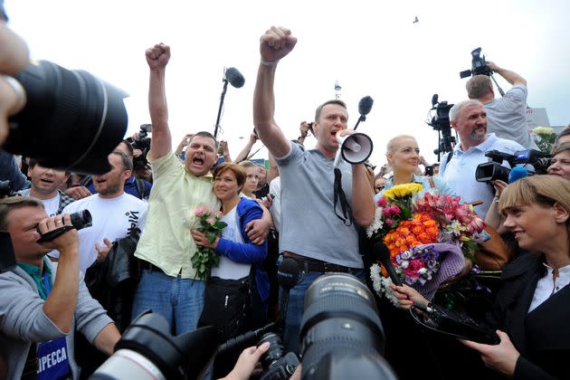 Navalny addresses supporters and journalists next to his former colleague Pyotr Ofitserov (center left) upon his arrival in a Moscow railway station, July 20, 2013.