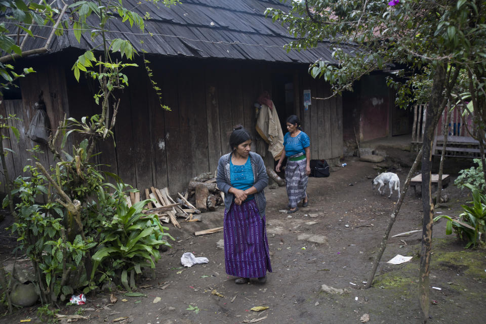 Catarina Alonzo Perez, mother of Felipe Gomez Alonzo, and her sister-in-law Maria, step outside their home in Yalambojoch, Guatemala, Saturday, Dec. 29, 2018. The hamlet is set on a plain and surrounded by spectacular, pine-covered mountains. It's also a place of crushing poverty and lack of opportunity. (AP Photo/Moises Castillo)