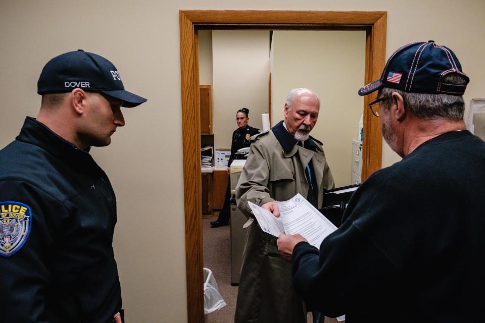 Dover Mayor Richard Homrighausen hands paperwork to Safety Director Gerald Mroczkowski after firing him, the mayor's secretary, and the safety director, Tuesday, Dec 21 in Dover.