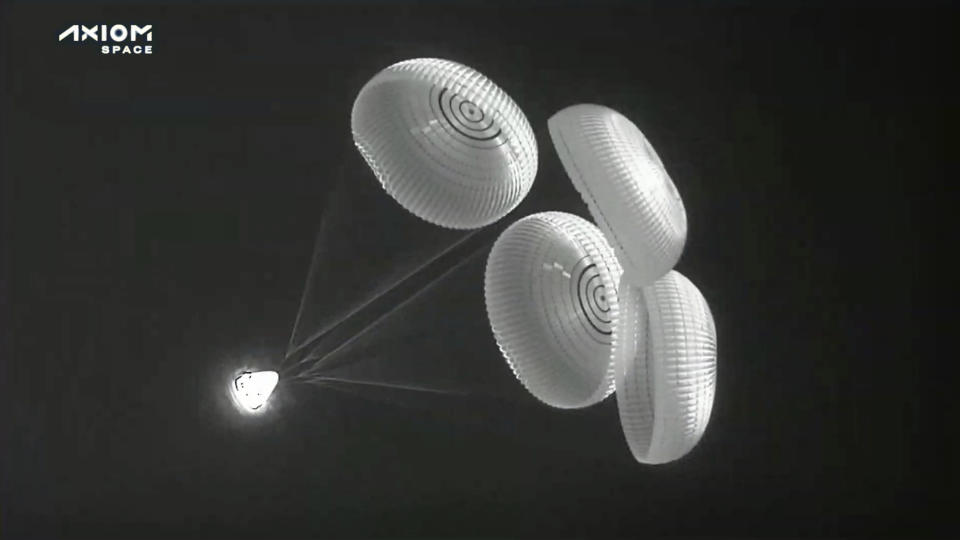 In this image from infrared video provided by SpaceX, the Dragon space capsule uses parachutes as it descends to the Atlantic Ocean off the Florida coast on Monday, April 25, 2022. Three rich businessmen returned from the International Space Station with their astronaut escort, wrapping up a pricey trip that marked NASA’s debut as a B&B host. (SpaceX via AP)