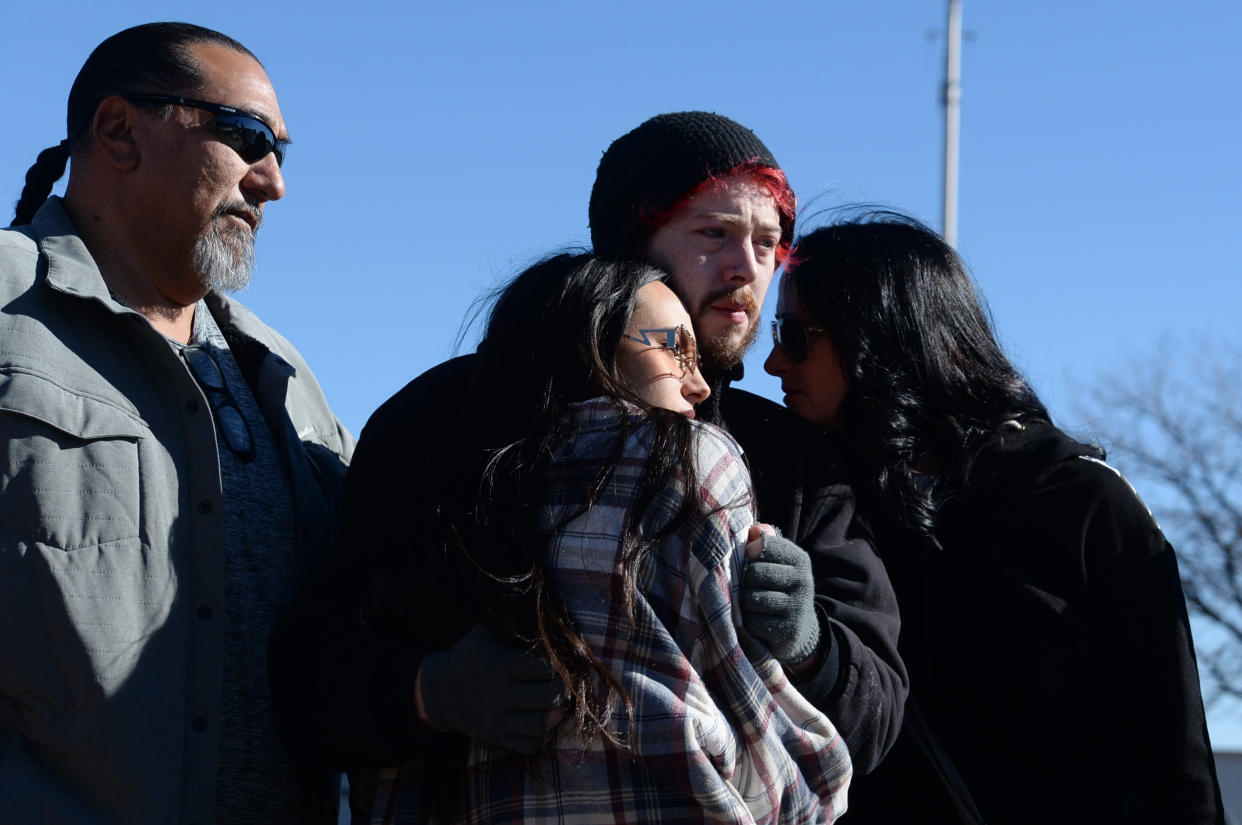 Fred Ramirez, Trinity Ramirez, Tim Bates, and Malissa Ramirez grieve near a gay nightclub in Colorado Springs, Colo., Sunday, Nov. 20, 2022, where a shooting occurred late Saturday night. (AP Photo/Geneva Heffernan)