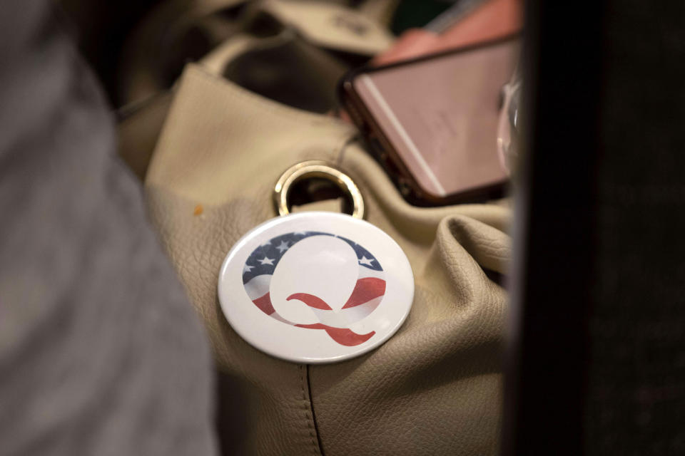 A QAnon conspiracy theory button sits affixed to the purse of an attendee of the Nebraska Election Integrity Forum on Saturday, Aug. 27, 2022, in Omaha, Neb. (AP Photo/Rebecca S. Gratz)
