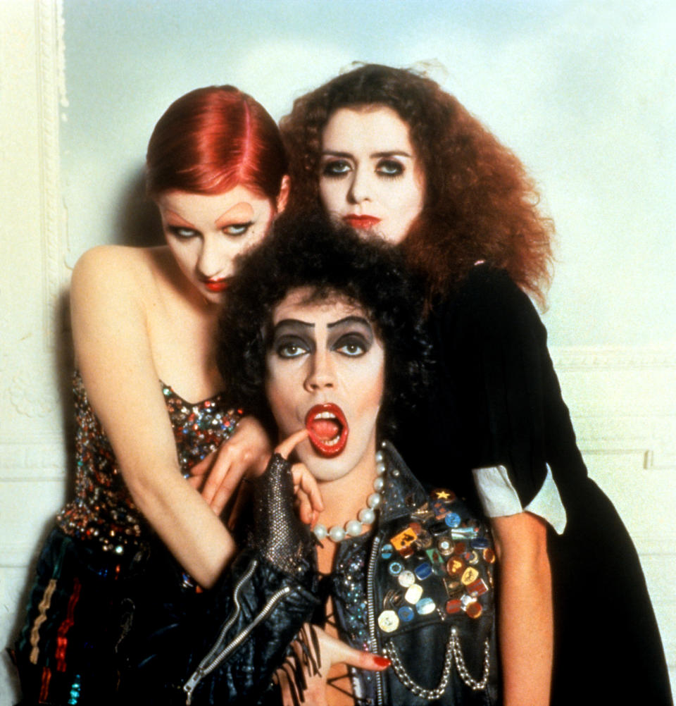 The image features Tim Curry, Susan Sarandon, and Patricia Quinn dressed in their iconic costumes from "The Rocky Horror Picture Show."